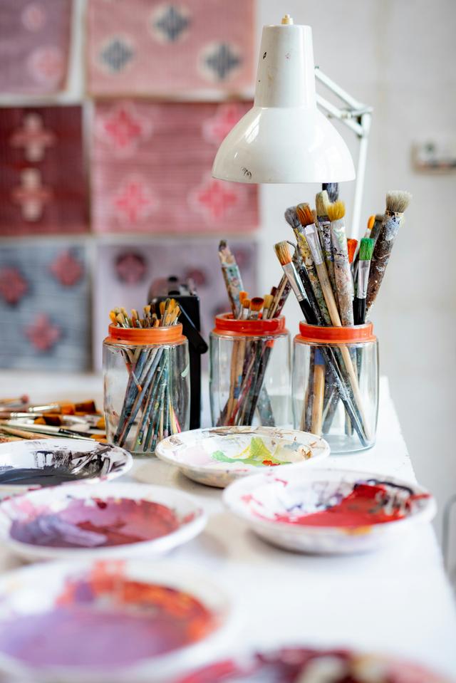 Farben und Pinsel an einem kreativen Arbeitsplatz